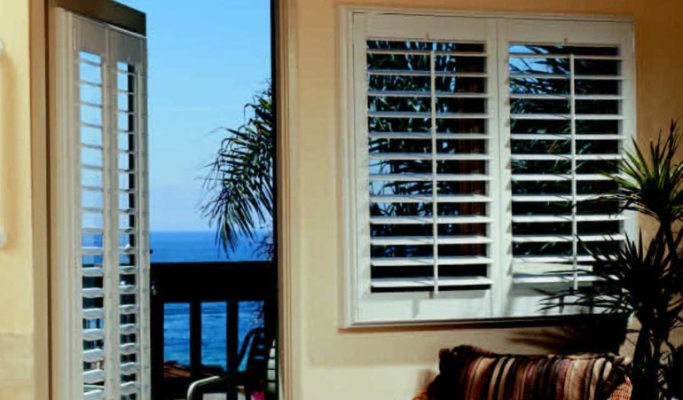 Living room with shutters and view of beach